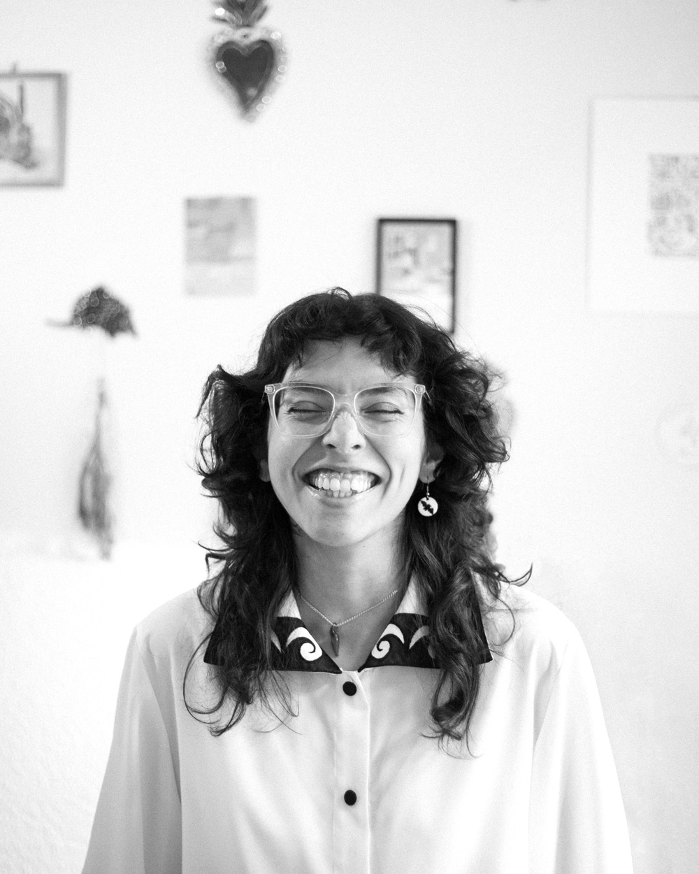 portrait of Elisa dressed in a white shirt and standing on a yellow background